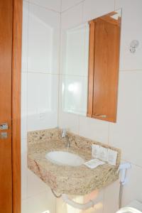 a bathroom with a sink and a mirror at Tapajos Palace Hotel in Novo Progresso