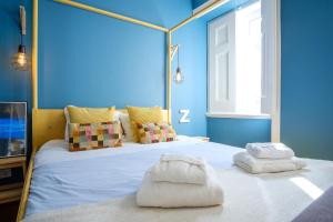 um quarto com uma cama grande e paredes azuis em Colourful Alfama Apartment em Lisboa