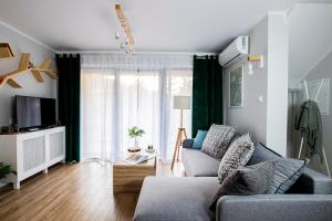 - un salon avec un canapé et une télévision dans l'établissement Apartamenty KDN Szczyrk, à Szczyrk