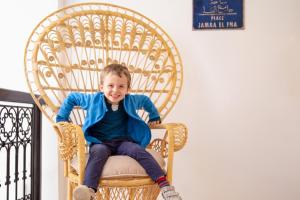 a young boy sitting in a wicker chair at Riad Al Rimal in Marrakech