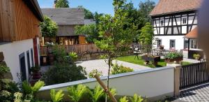 a backyard of a house with a white fence at Hossies Hof - Luxus Ferienwohnung Alter Stall in Bertsdorf