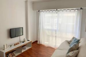 sala de estar con sofá y TV en Luminoso departamento, moderno y de diseño en Buenos Aires