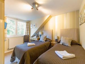 una camera d'albergo con due letti e una finestra di OYO Arden Guest House, Craigmillar Castle Edinburgh a Edimburgo