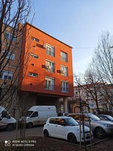een gebouw waar auto's voor geparkeerd staan bij Centrum 2 apartman in Szolnok