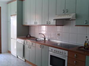 a kitchen with white cabinets and a sink at Angoiko Etxea in Bacáicoa