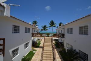 une passerelle entre deux bâtiments avec l'océan en arrière-plan dans l'établissement Itamaracá Apartments, à Itamaracá