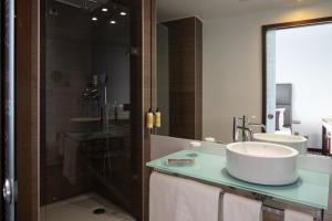 a bathroom with a sink, mirror, and bathtub at NEYA Lisboa Hotel in Lisbon