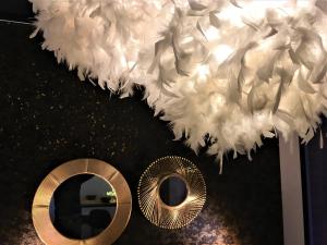 a bunch of white feathers hanging over a mirror at GOLD Suite & Spa in Nantes