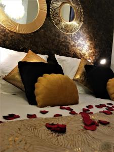 Una cama con rosas rojas y espejos. en Opéra Suite&Spa, en Nantes