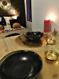 a black plate on a wooden table with wine glasses at GOLD Suite & Spa in Nantes