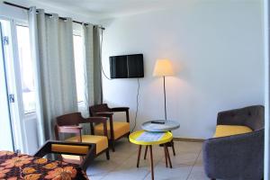 a room with chairs and a bed and a tv at Bungalow Beach Hotel in Serekunda