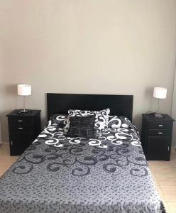 a bedroom with a bed with a black and white comforter at DEPARTAMENTO SANTA FE CON COCHERA gratis in Santa Fe
