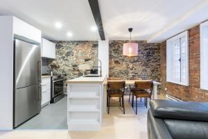 a kitchen with a table with chairs and a refrigerator at Les Lofts St-Paul - Par Les Lofts Vieux-Québec in Quebec City
