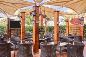 an outdoor patio with chairs and tables and a screen at Holiday Inn Citystars, an IHG Hotel in Cairo
