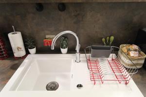 a kitchen counter with a sink with a faucet at Studio atypique et cosy, classé Gîte de France, CLIMATISATION, lit Queen Size, lave-vaisselle, Netflix, wifi, 400m centre, parking, 15min gare, boîte à clés, Gîtes La Tarine in Albertville +19 photos