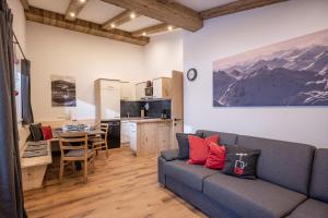 a living room with a couch and a kitchen at Chalet Tirol in Westendorf