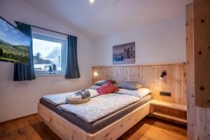 ein Schlafzimmer mit einem Holzbett und einem Fenster in der Unterkunft Chalet Tirol in Westendorf