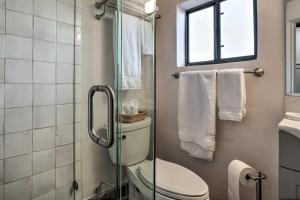 a bathroom with a toilet and a window and towels at Adobe House with Patio - Walk to Dtwn Plaza and Shops! in Santa Fe +18 photos