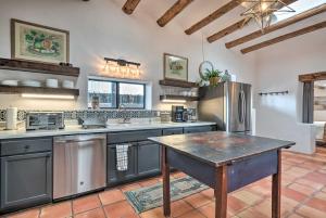 a kitchen with stainless steel appliances and a table at Adobe House with Patio - Walk to Dtwn Plaza and Shops! in Santa Fe