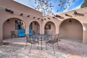 a patio with a table and chairs in front of a building at Adobe House with Patio - Walk to Dtwn Plaza and Shops! in Santa Fe