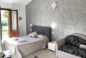 a bedroom with a bed and a chair at Le Falesie di Castelluzzo in Castelluzzo