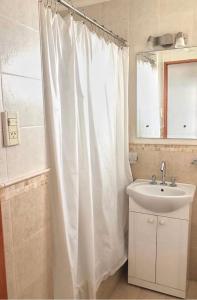 a bathroom with a white shower curtain and a sink at DEPARTAMENTO SANTA FE CON COCHERA gratis in Santa Fe