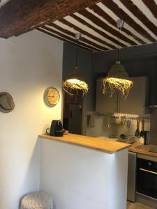 a kitchen with two pendant lights hanging over a counter at Cassis et ses trésors in Cassis