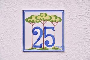un cartel con árboles y el número en una pared en Maison Twentyfive en Isquia