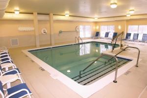 - une piscine dans une salle d'hôpital entourée de chaises dans l'établissement Holiday Inn Grand Rapids-Airport, an IHG Hotel, à Grand Rapids