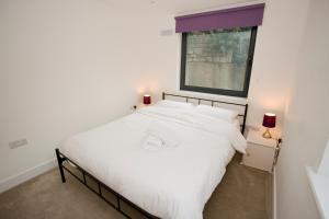 - un lit blanc dans une chambre avec fenêtre dans l'établissement 8 Compass Point, à Bournemouth