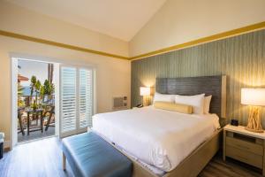 a bedroom with a large bed and a balcony at Inn at the Cove in Pismo Beach