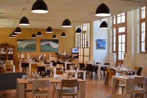 un comedor con mesas, sillas y ventanas en Hotel Saint Louis Beaulieu - Bordeaux, en Burdeos