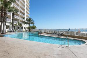 ein Swimmingpool mit Palmen und einem Gebäude in der Unterkunft Admirals Quarters in Orange Beach