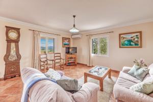 a living room with two couches and a grandfather clock at Can Claret in Caʼs Concos