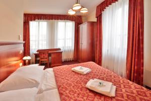 a hotel room with a bed with two towels on it at Arkada Hotel Praha in Prague