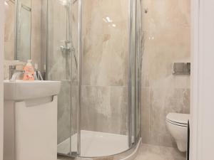 a bathroom with a shower and a sink and a toilet at Apartamenty Aleksandry Apartament Eli in Świnoujście