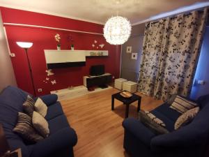 sala de estar con sofá azul y pared roja en Perera, en Castejón de Sos