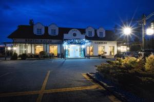 a store front at night with lights at Hotel Campari in Góra Motyczna