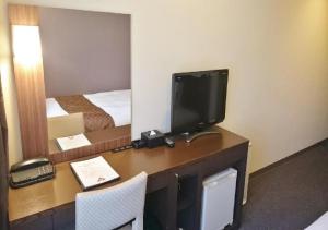 a room with a desk with a television and a bed at Hotel Ascent Plaza Hamamatsu / Vacation STAY 64699 in Hamamatsu