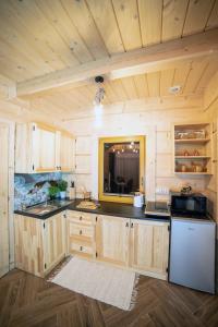 a kitchen with wooden cabinets and a counter top at Domki Masny Chochołów in Chochołów