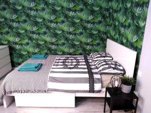 ein Schlafzimmer mit einem Bett mit einer grünen Wand in der Unterkunft Apartament Be Happy Nr 1 in Gdynia