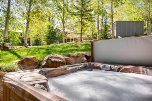 a hot tub in a backyard with rocks and trees at Foxglove Condos in Park City