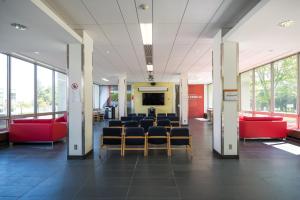 une salle d'attente avec des chaises et un écran dans un bâtiment dans l'établissement Résidences Université Laval, à Québec