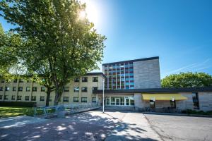 un edificio con un árbol delante de él en Résidences Université Laval, en Quebec