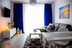 ルブリンにあるBlue Dreamのリビングルーム(青いカーテン、ソファ付)