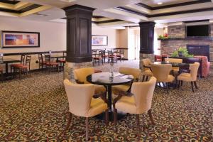 un vestíbulo con mesas, sillas y chimenea en Holiday Inn Express Hotel & Suites Lincoln-Roseville Area, an IHG Hotel, en Roseville