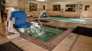 a swimming pool with a blue chair and a chair at Holiday Inn Express Hotel & Suites Lincoln-Roseville Area, an IHG Hotel in Roseville