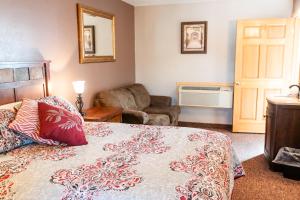 a bedroom with a bed and a couch and a chair at Circle R Motel in East Glacier Park