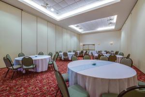 a room with white tables and chairs in it at Holiday Inn Express Hotel & Suites Greensboro-East by IHG in Greensboro +24 photos