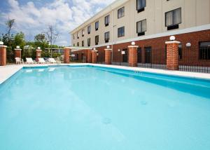 a large blue swimming pool in front of a building at Holiday Inn Express Hotel & Suites Greensboro-East, an IHG Hotel in Greensboro